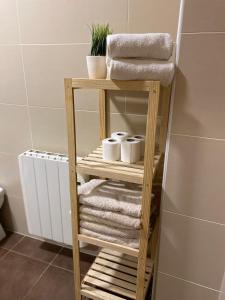 - Baño con toallero de madera y toallas en Alma Apartamento, en Daimuz Bajo