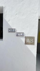 two signs on the side of a white building at Casa Ayla Montecastillo A8 in Caleta De Fuste