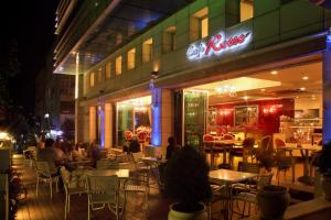 Ramada by Wyndham Ankara في أنقرة: الناس يجلسون على الطاولات خارج المطعم في الليل