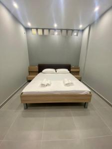 a bedroom with a bed with two towels on it at Central Square Family Apartment in Nea Kalikratia +9 photos