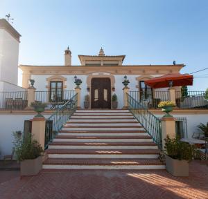 una casa con escaleras que conducen a un edificio en La Villa del Pantano, en Olmedilla de Alarcón