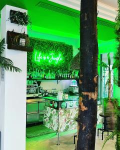 a green bar with a kitchen with a stove at Hotel Montecarlo - Vista Mare con Piscina & Area Fitness in Riccione