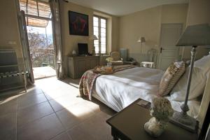 um quarto com uma cama e uma mesa com um candeeiro em Le Couvent D'Herepian em Hérépian