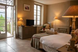 埃雷皮揚的住宿－埃雷皮昂修道院酒店，一间卧室设有一张床、一台电视和一个阳台。
