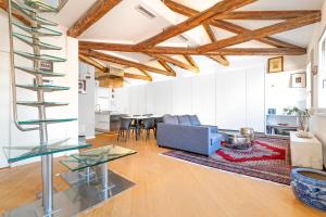 an open living room with wooden ceilings and a spiral staircase at Ca' Algi - Luxury San Marco View in Venice