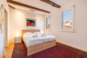 a bedroom with a bed and a red rug at Ca' Algi - Luxury San Marco View in Venice