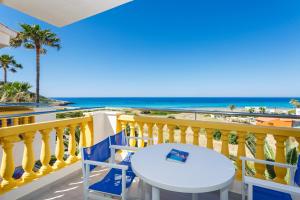 a table and chairs on a balcony with the beach at Royal Son Bou Family Club in Son Bou