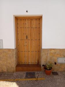 una puerta de madera con una maceta delante de ella en Agradable casa rural con chimenea y buenas vistas, en Cañaveral de León