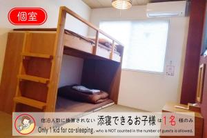 Etagenbett in einem Zimmer mit einer Person, die auf dem Boden schläft in der Unterkunft USJに一番近いゲストハウス J-Hoppers Osaka Universal in Osaka