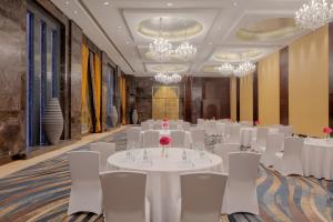 a banquet hall with white tables and chairs and chandeliers at Raffles Dubai in Dubai +114 photos