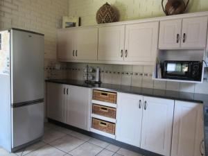 a kitchen with white cabinets and a refrigerator at Manzini Chalet No 34 in St Lucia