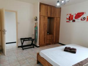 een slaapkamer met 2 bedden en een houten kast bij Les Camelias Ground Floor in Flic-en-Flac
