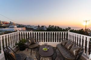 a balcony with a table and chairs with a sunset at Amarie House with Sea View & Sunset View in Oia