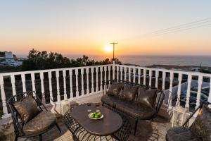 a table and chairs on a balcony with a sunset at Amarie House with Sea View & Sunset View in Oia