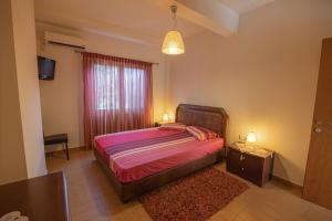 1 dormitorio con cama, ventana y alfombra en Villa Cleio en Archanes