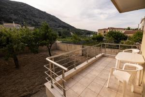 balcón con mesa, sillas y montaña en Villa Cleio en Archanes