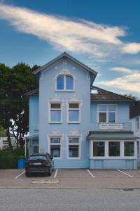 ein blaues Gebäude mit einem davor geparkt in der Unterkunft Haus Magdalene in Bad Schwartau