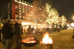 a group of people standing around a fire in front of a building at Parkhotel Pörtschach - Das Hotelresort mit Insellage am Wörthersee in Pörtschach am Wörthersee +81 photos