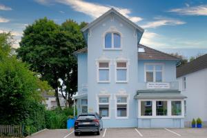 una casa azul con un coche aparcado delante de ella en Haus Magdalene, en Bad Schwartau