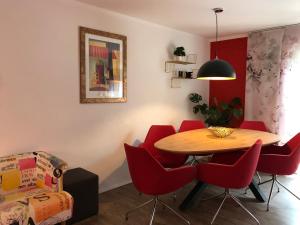 comedor con mesa y sillas rojas en Große Prinzessin - Appartement mit Saunanutzung, en Burgbernheim
