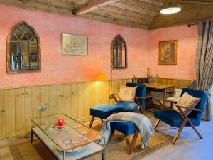 a living room with a table and chairs and a table at The Potting Shed in Huntingdon