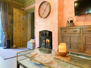 sala de estar con chimenea y mesa de cristal en The Potting Shed, en Huntingdon