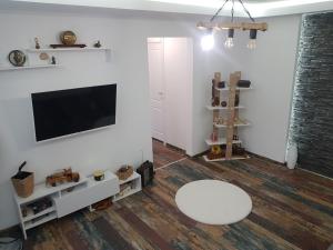 uma sala de estar com uma televisão e uma mesa branca em Lara Apartament em Iaşi