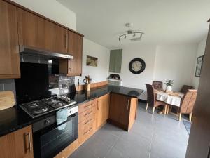 une cuisine avec une cuisinière et une salle à manger dans l'établissement Modern mid terrace villa, Royston, Barnsley, à Royston 14 autres photos
