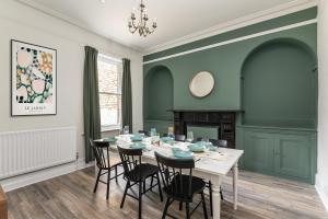 a dining room with green walls and a white table and chairs at Stunning Skipton House by Yorksha Property in Skipton +31 photos