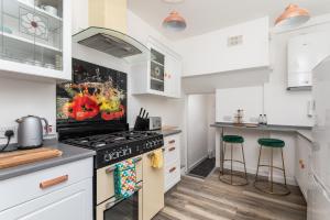 a kitchen with white cabinets and a stove top oven at Stunning Skipton House by Yorksha Property in Skipton