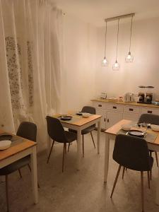 una cocina con mesas y sillas en una habitación en b & b ultimo miglio en Treviso