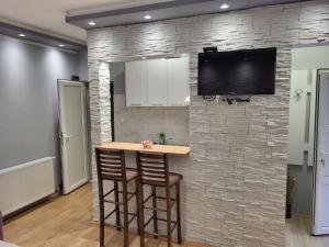 a kitchen with a bar against a stone wall at Čavić apartmani in Vršac