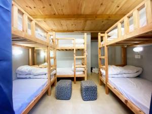 a room with three bunk beds in a hostel at Woodzo Shangarh in Sainj