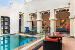 a hotel lobby with a pool and a table and chairs at Al Maya Island & Resort in Abu Dhabi