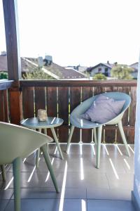 een patio met 2 stoelen en een tafel op een balkon bij Ferienwohnung "Wie dahoam" in Chieming
