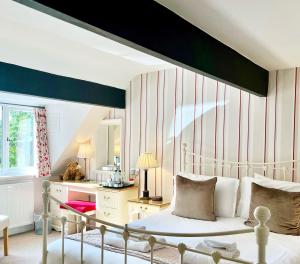 een slaapkamer met een bed en een bureau met een spiegel bij Mallyan Spout Hotel in Goathland