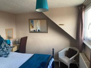 a bedroom with a bed and a mirror and a chair at White Heather Guest House in Mablethorpe