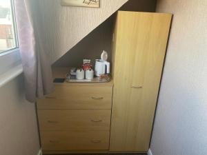 a wooden dresser in a room with a staircase at White Heather Guest House in Mablethorpe