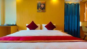 ein Schlafzimmer mit einem großen weißen Bett mit roten Kissen in der Unterkunft Hotel Grand View in Kathmandu