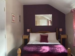 a bedroom with a bed with a purple blanket at White Heather Guest House in Mablethorpe