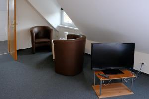 Zimmer mit einem TV, einem Tisch und Stühlen in der Unterkunft Haus Magdalene in Bad Schwartau