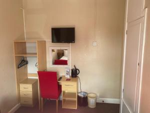 a room with a desk and a red chair at White Heather Guest House in Mablethorpe