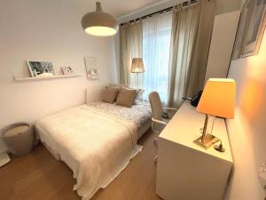 a bedroom with a bed and a desk with a lamp at Jauna Teika Cosy 1bdr apartment, self check-in in Rīga