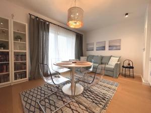 sala de estar con mesa, sillas y sofá en Jauna Teika Cosy 1bdr apartment, self check-in, en Riga