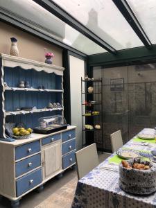 ein Esszimmer mit einem Tisch und einem blauen Schrank in der Unterkunft B&B De Vlasboerderij in Zonnemaire