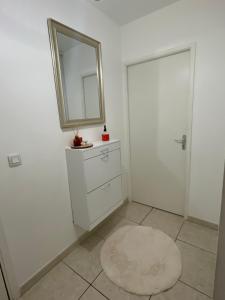 - une salle de bains blanche avec un miroir et une commode blanche dans l'établissement RB Home, à Marseille