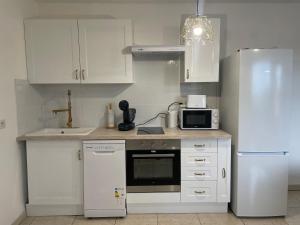  La cuisine est équipée de placards blancs et d'un réfrigérateur. dans l'établissement RB Home, à Marseille