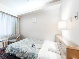 a hotel room with a bed and a desk at Hotel Tetora Spirit Sapporo in Sapporo