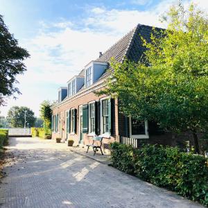 a brick building with a bench in front of it at Bed & Breakfast [H]eerlijk! in De Kwakel