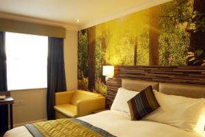 a hotel room with a large bed and a painting on the wall at Diamond Lodge in Manchester